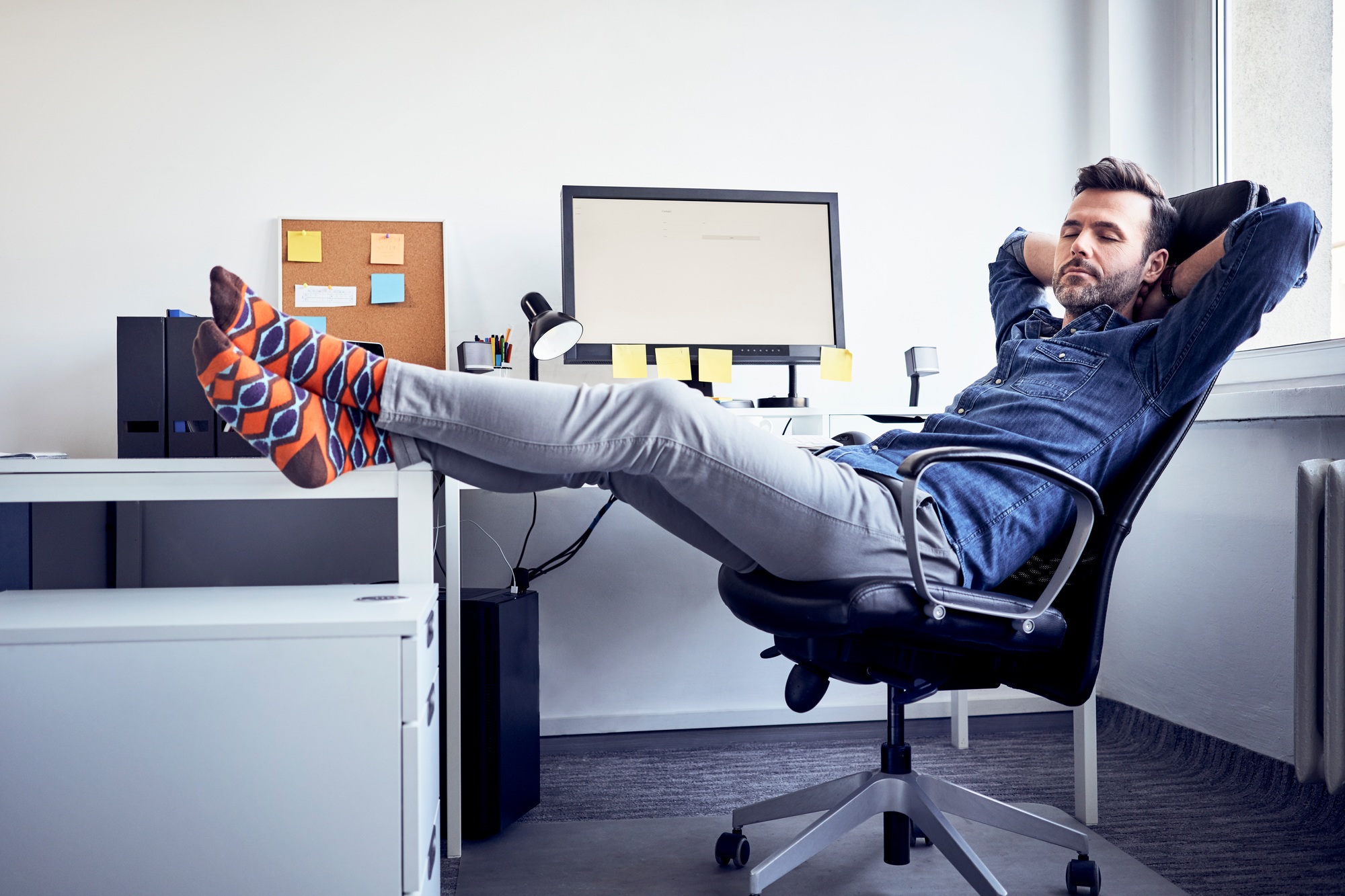 Man sitting at desk in office having a power nap
